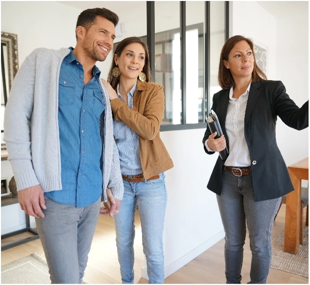 A real estate agent showing a young couple a home