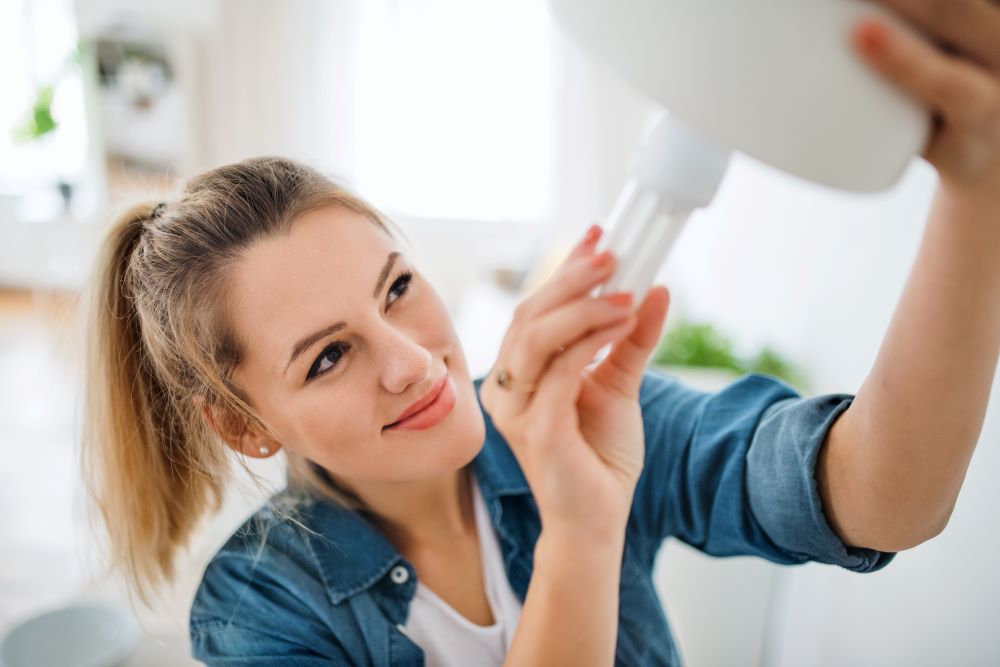 woman changing lightbulb